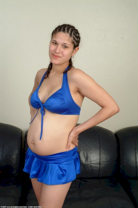 Pregnant amateur shows off her hairy pussy while standing naked - Photo 1