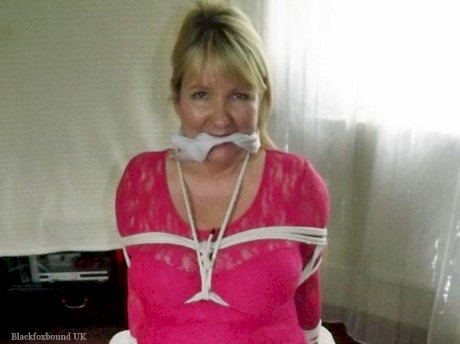 Mature lady with blonde hair ha her big naturals exposed after being tied up