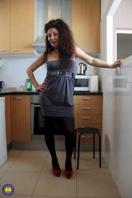 Spanish housewife with big hair masturbates with a cucumber in her kitchen