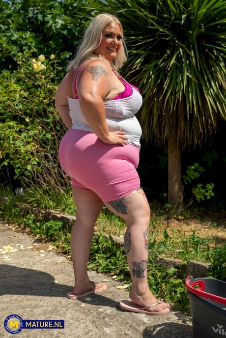 Middle-aged blonde woman displays her massive ass after washing her car - Photo 2