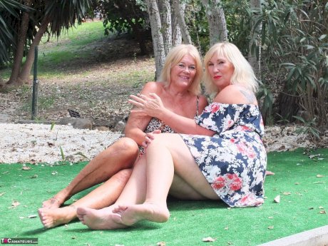 Mature woman Melody and her lesbian lover fondle each others boobs outdoors