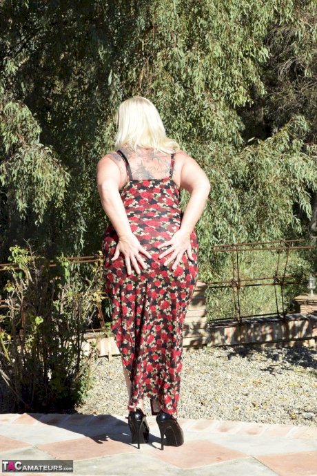 Fat blonde granny Melody looses her big butt from a long dress while outdoors