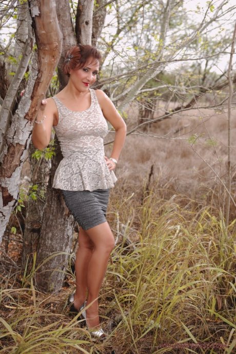 Mature pinup model Roni Ford kicks off pumps wearing retro lingerie in woods - Photo 1