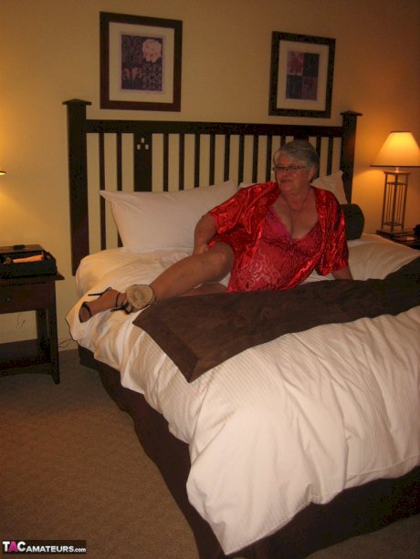 Fat granny Girdle Goddess whips out her big boobs on a bed in pantyhose