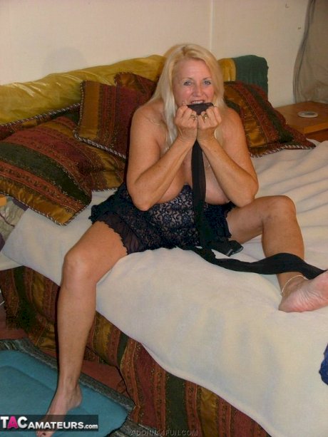 Blonde granny Adonna removes her stockings before stuffing them in her pussy