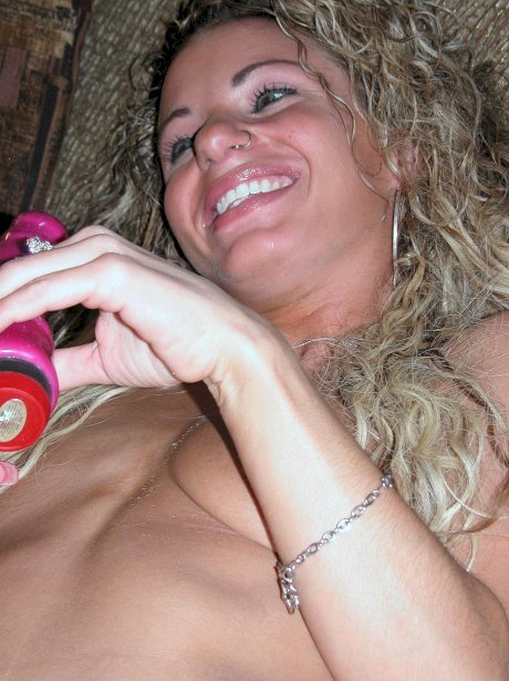 Slender curly-haired MILF Holly toys her tight love hole up close on the sofa
