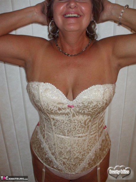 Older amateur Busty Bliss releases her big natural tits from a laced corset