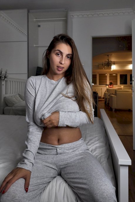 Amateur female with a nice set of breasts uncups them over her sweatpants - Photo 3