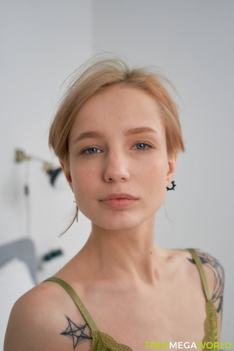 Pretty tattooed teen Tea Mint exposes her slim body and rubs her clit