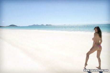 Busty Asian model Tera Patrick removes bikini bottoms to pose nude in the sea