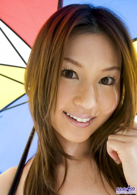 Sexy Japanese girl Tatsumi Yui holds an umbrella while standing naked