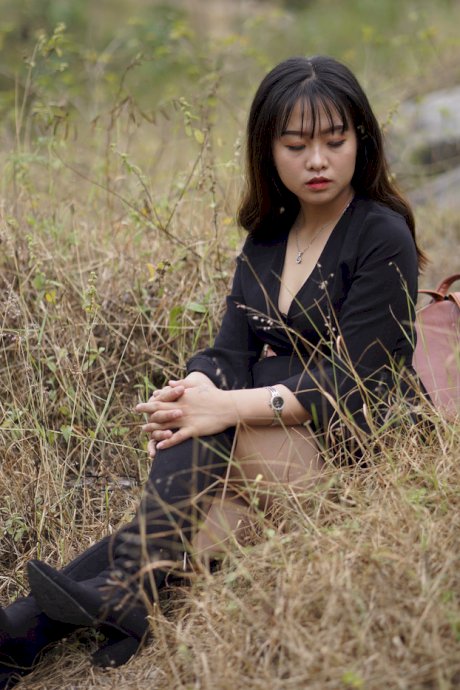 Gorgeous Asian babe posing in her black dress and boots in nature
