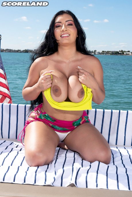 Dark-haired Latina female Selena Adams bares her large boobs on a boat