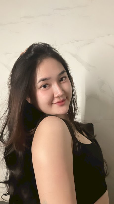 Petite Asian teen Lotus Huahang flaunts her big bum and natural tits