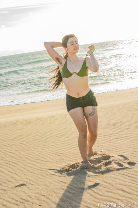 Beauty Kisa Fae strips her green bikini on the beach & shows her hairy body