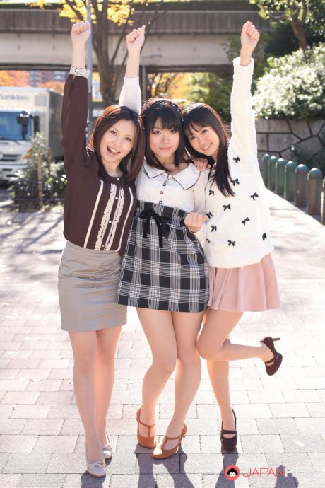 Three Japanese girls in skirts pose outdoors for a SFW shoot