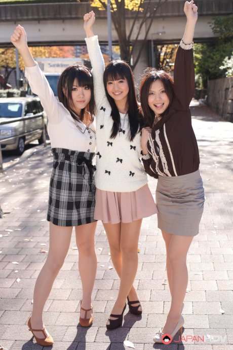 Three Japanese girls in skirts pose outdoors for a SFW shoot