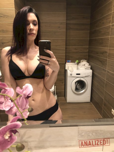 Brunette solo girl takes mirror selfies while getting naked in a bathroom