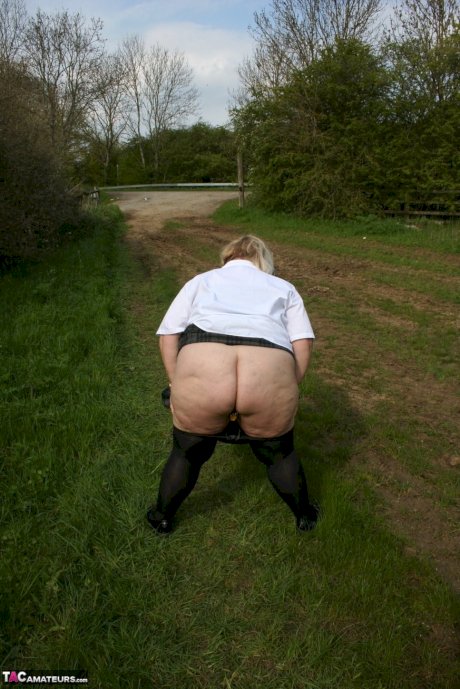 Thick British woman Lexie Cummings exposes herself in a field while wearing hose - Photo 16