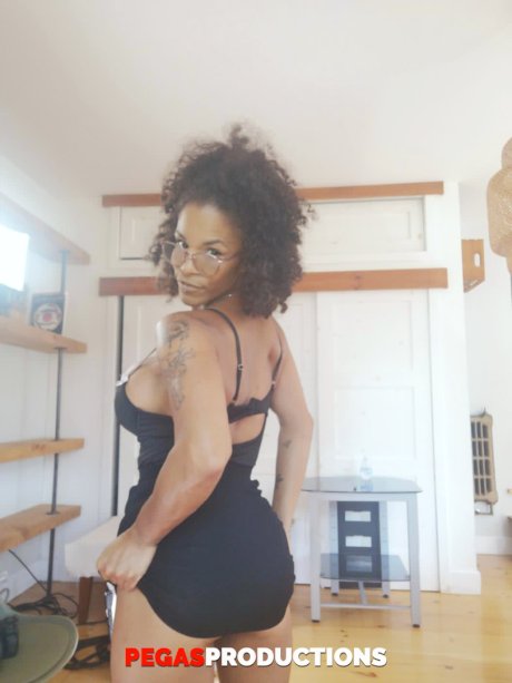 Curly-haired beauty with big tits AJ strips and poses butt naked