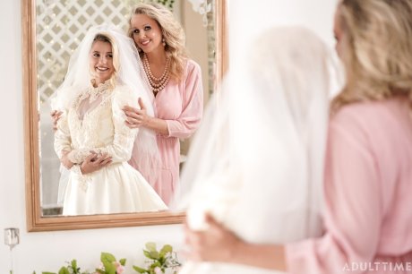 Carolina Sweets is affixed with a garter before a lesbian wedding to Julia Ann