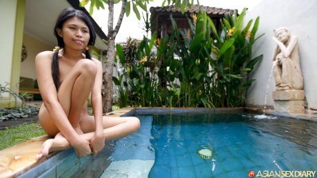 Cute Asian teen Adelia shows off her sexy body & gets in the pool while naked