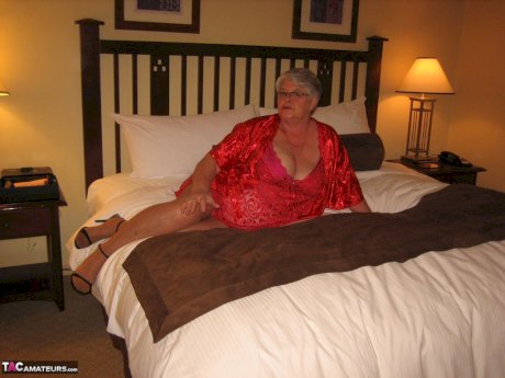 Fat granny Girdle Goddess whips out her big boobs on a bed in pantyhose