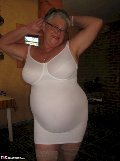 Fat granny Girdle Goddess holds her saggy tits in her hands by a pillar