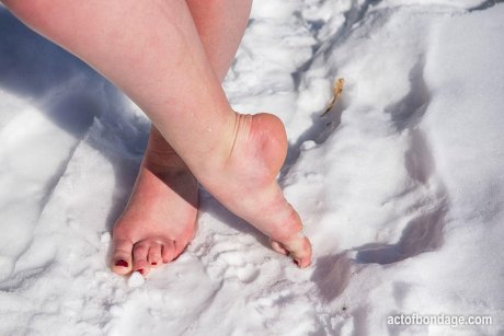 Brunette BBW rids ball gag and ropes while posing nude and barefoot in snow