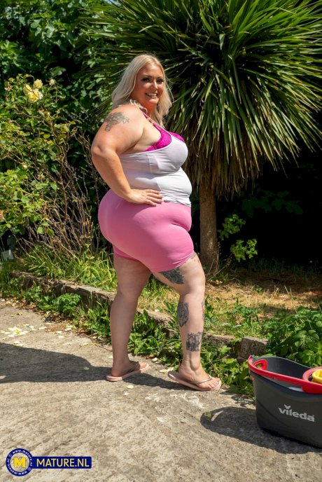 Middle-aged blonde woman displays her massive ass after washing her car - Photo 3