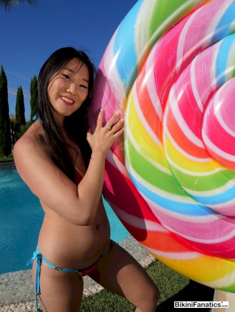 Japanese beauty Katana models a bikini next to an inground swimming pool