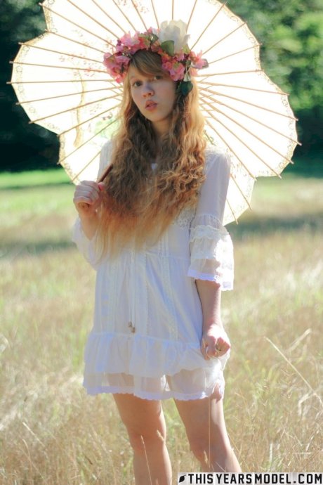 Charming redheaded teen Dolly Little holds a parasol while getting naked - Photo 5