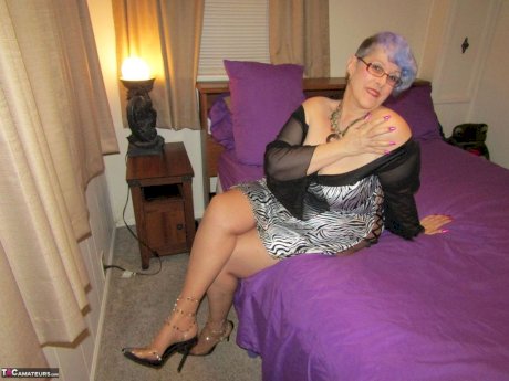 Old woman Bunny Gram shows her hose covered pussy on a bed in pointy shoes