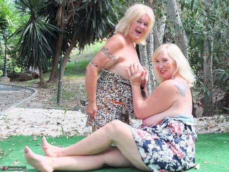 Mature woman Melody and her lesbian lover fondle each others boobs outdoors