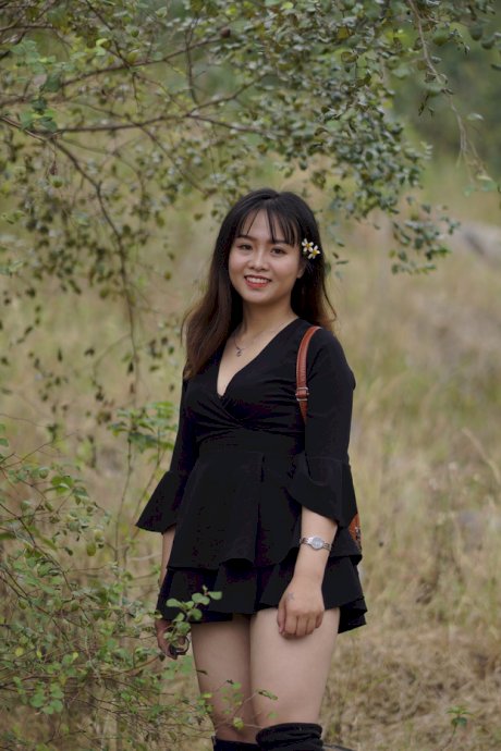 Gorgeous Asian babe posing in her black dress and boots in nature