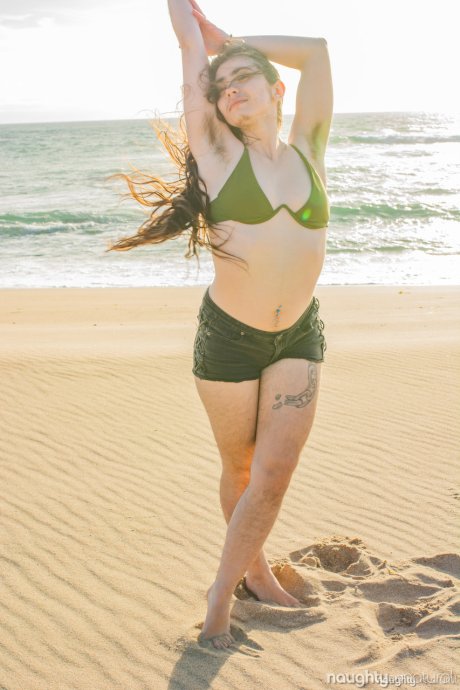 Beauty Kisa Fae strips her green bikini on the beach & shows her hairy body