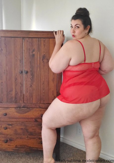 Fatty in a red negligee Lady Sublime flaunts her big juggs while sucking a toy