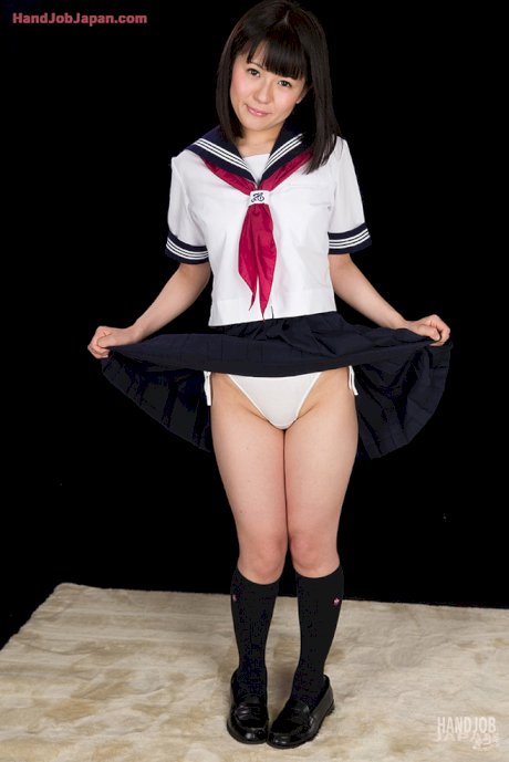 Japanese girl in sailor uniform jerks a cock until it blows its load of jizz