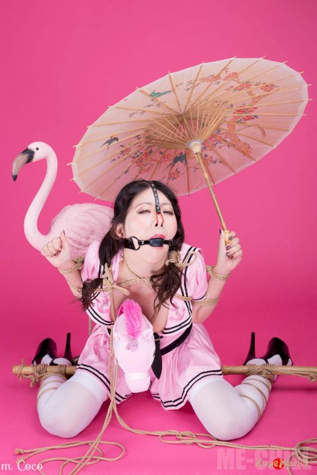 Asian solo girl Coco holds a parasol after being bound and ball gagged