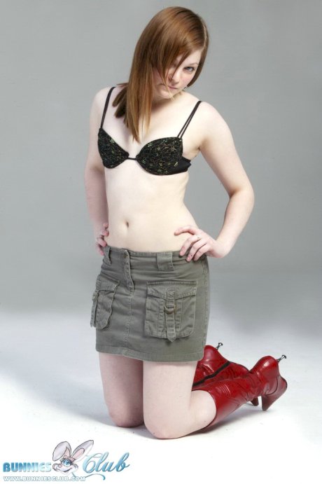Pale redhead Lilly slowly strips to a black G-string and red leather boots