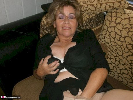 Old woman with large boobs pulls down pantyhose to finger her natural pussy